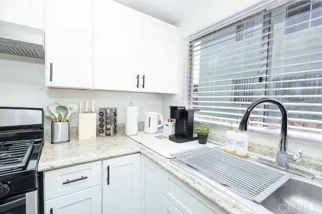 a kitchen with granite countertop a sink and a stove
