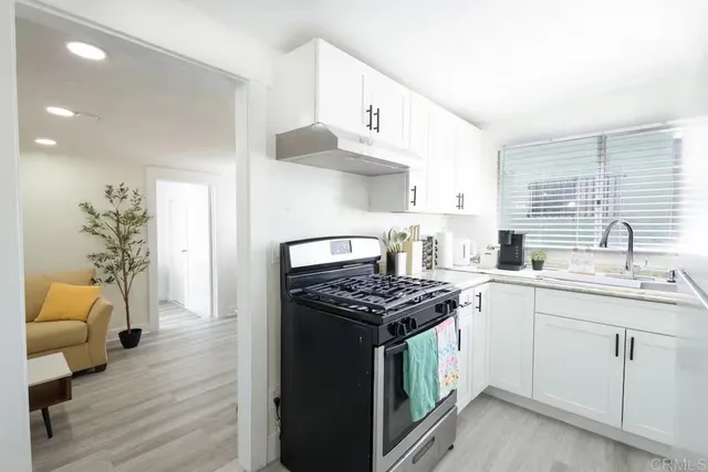 a kitchen with stainless steel appliances a stove a sink and cabinets
