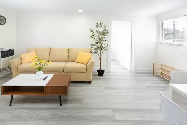 a living room with furniture a rug and a table
