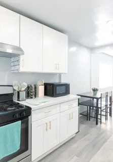 a kitchen with a stove and white cabinets