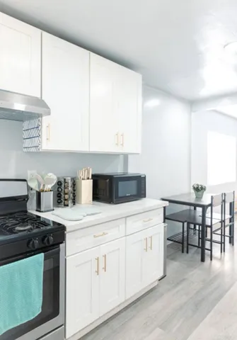 a kitchen with a stove and white cabinets