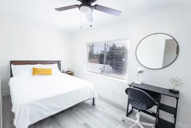 a bedroom with a bed a dresser and a chandelier