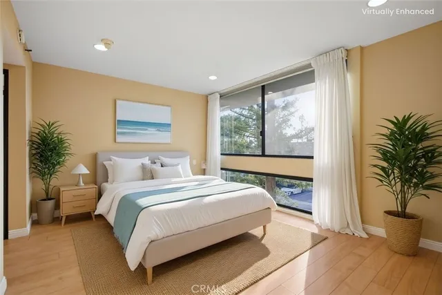 a bedroom with a large bed and a potted plant