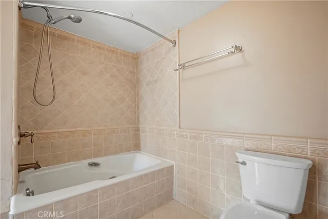 a bathroom with a tub a toilet and a shower