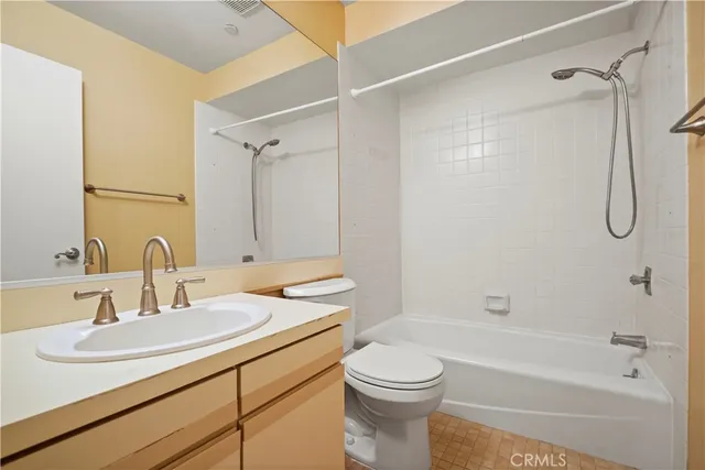 a bathroom with a granite countertop sink a toilet and shower