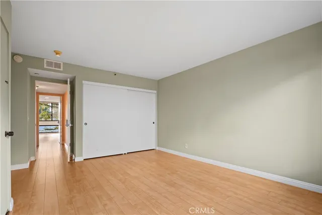 an empty room with wooden floor and closet