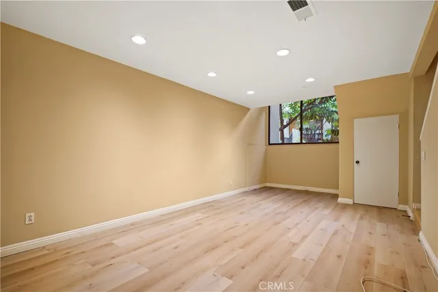 an empty room with wooden floor and entrance