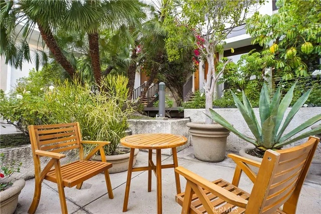 a view of a patio with table and chairs and potted plants