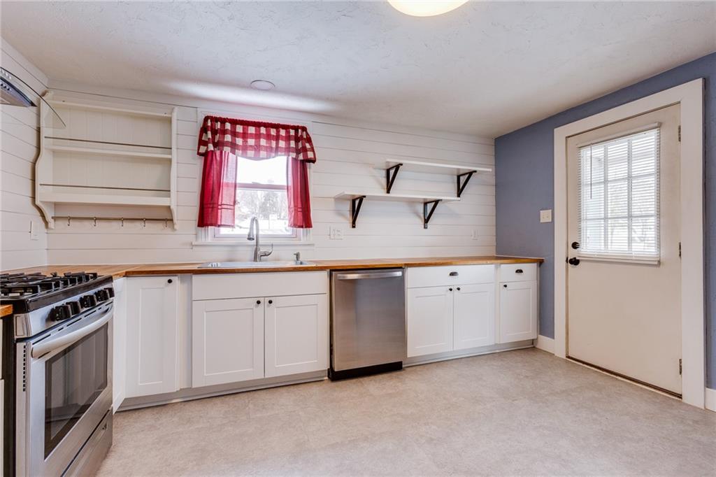 11561 Center Street Irwin, PA 15642 - Photo 15 of 46 a kitchen with granite countertop a stove a sink and a microwave