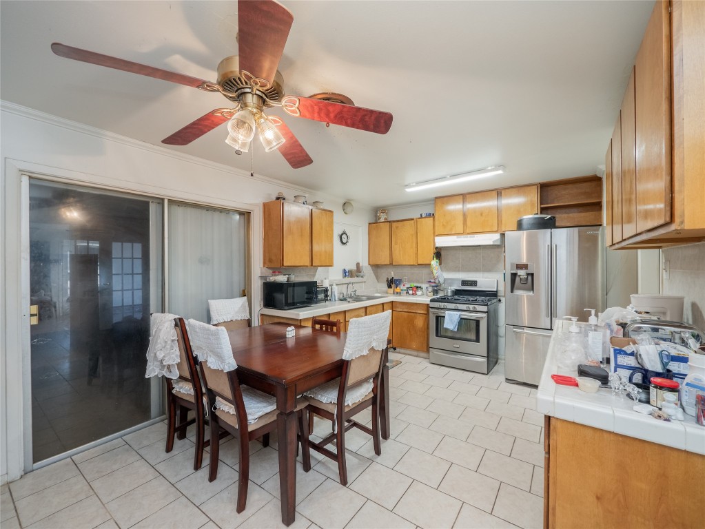 1409 Zephyr Road Killeen, TX 76541 - Photo 7 of 31 a kitchen with stainless steel appliances granite countertop a refrigerator a sink dishwasher a dining table and chairs with wooden floor