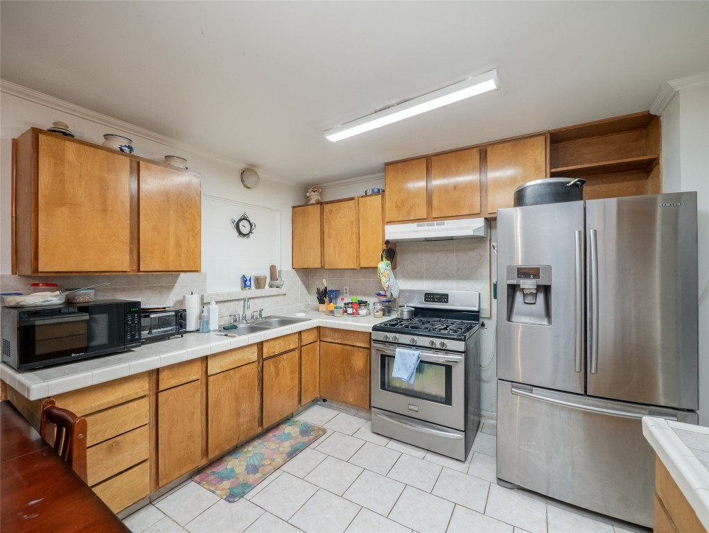 1409 Zephyr Road Killeen, TX 76541 - Photo 8 of 31 a kitchen with stainless steel appliances a refrigerator sink and microwave