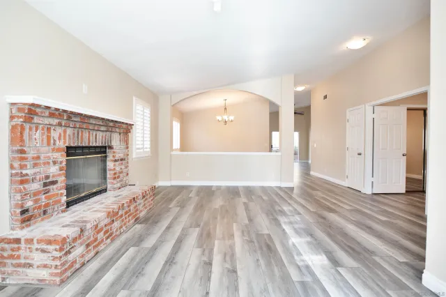 a view of empty room with wooden floor and fireplace