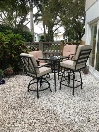 a view of backyard with couple of couch and trees