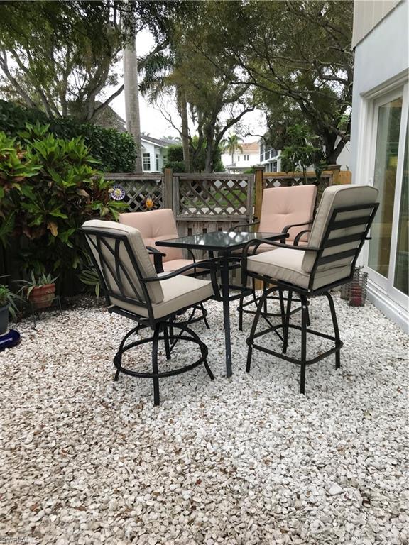 302 2nd Street South, Unit 302 Naples, FL 34102 - Photo 12 of 14 a backyard of a house with table and chairs