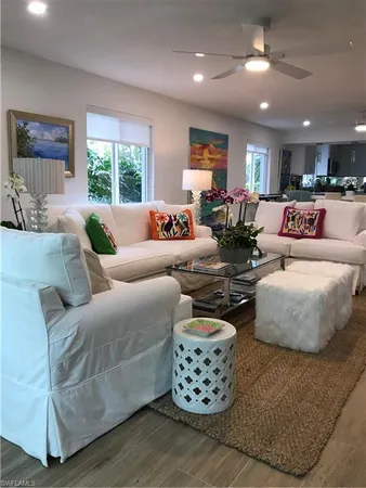 a living room with furniture a large window and a chandelier