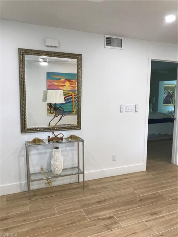 302 2nd Street South, Unit 302 Naples, FL 34102 - Photo 5 of 14 a room with wooden floor and furniture