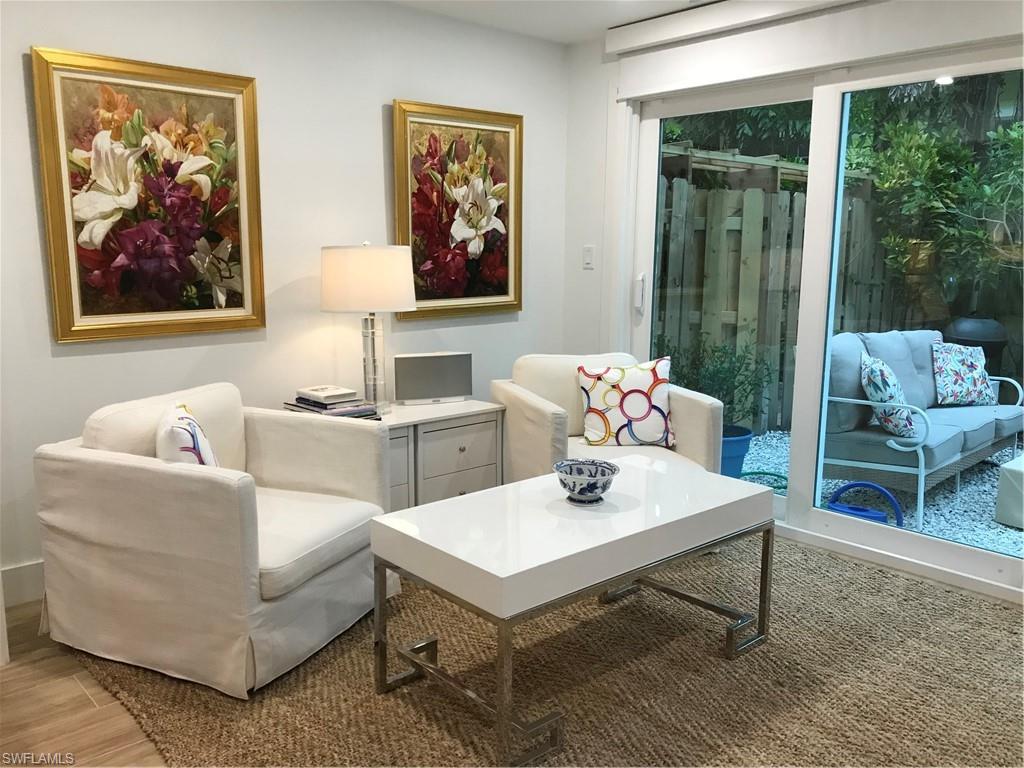 302 2nd Street South, Unit 302 Naples, FL 34102 - Photo 9 of 14 a living room with furniture a table and a painting on the wall