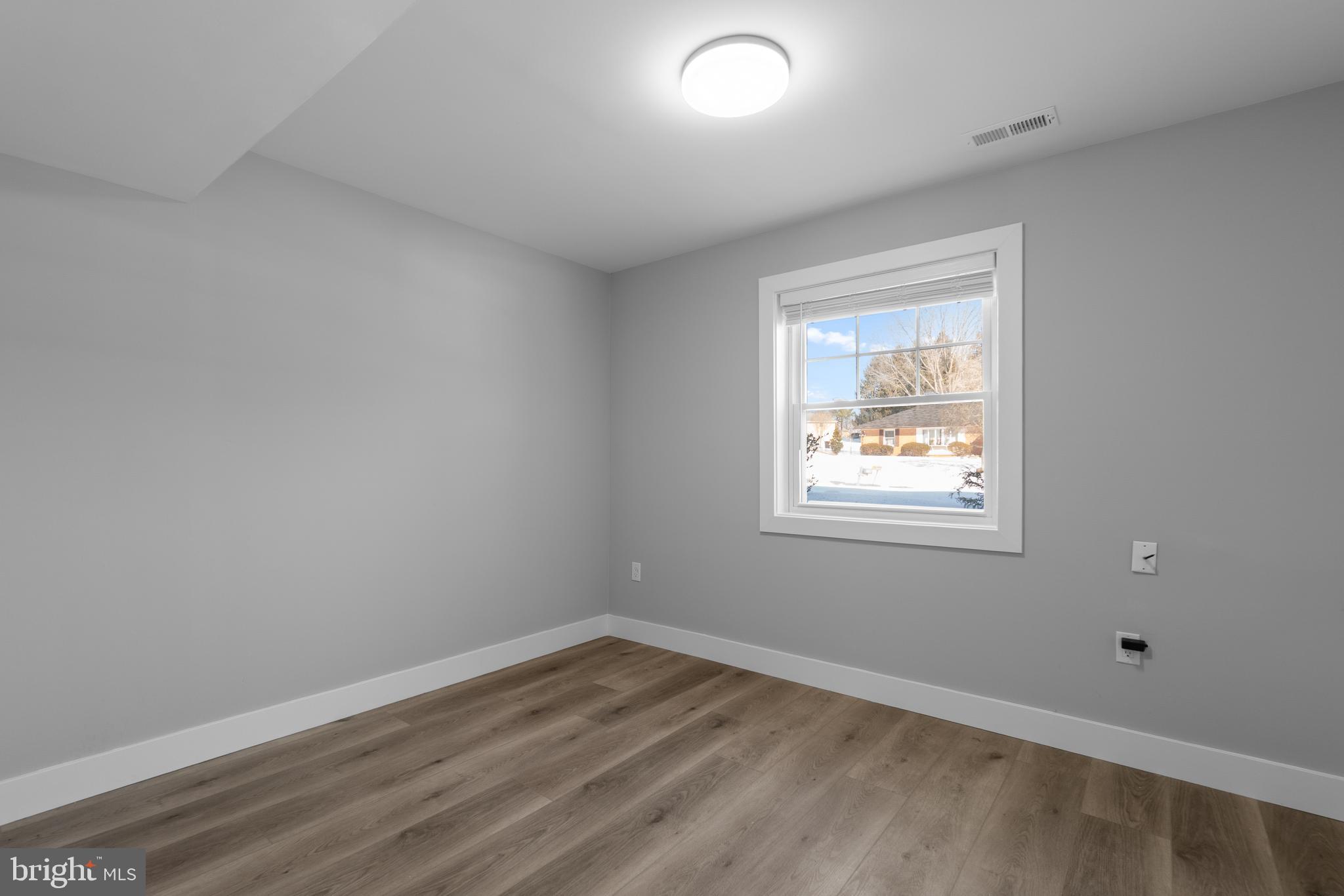 19104 Bloomfield Road Olney, MD 20832 - Photo 26 of 37 an empty room with wooden floor and windows