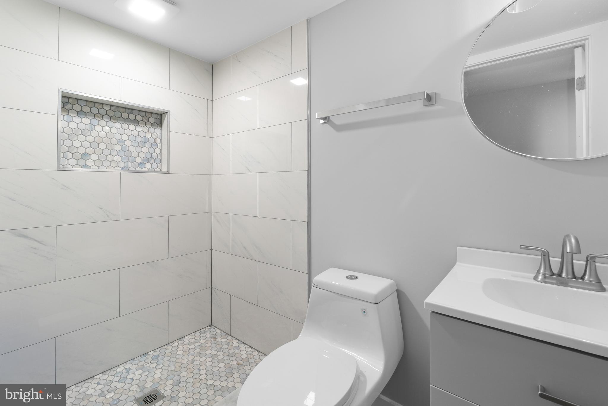 19104 Bloomfield Road Olney, MD 20832 - Photo 32 of 37 a bathroom with a toilet sink and mirror