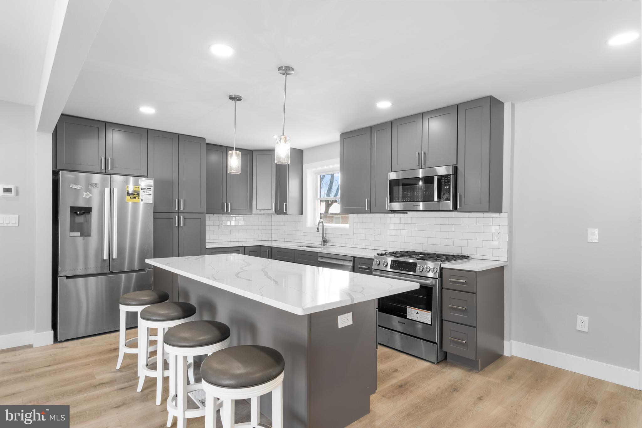 19104 Bloomfield Road Olney, MD 20832 - Photo 8 of 37 a kitchen with a table chairs refrigerator and microwave
