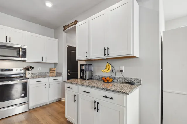 a kitchen with stainless steel appliances granite countertop a refrigerator stove and a sink
