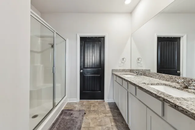 a bathroom with a granite countertop sink mirror and a shower