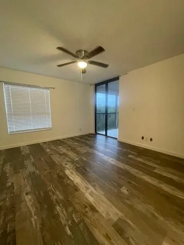 en empty room with wooden floor and windows