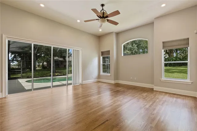 en empty room with windows and fan