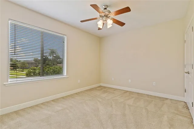 an empty room with closet and a ceiling fan
