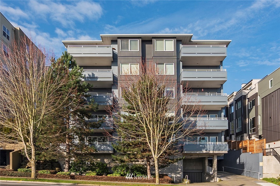 3112 Southwest Avalon Way, Unit 102 Seattle, WA 98126 - Photo 1 of 26 a front view of a building with a tree