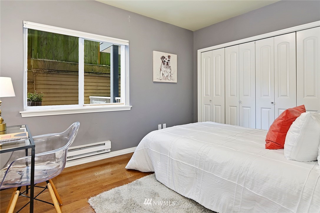 3112 Southwest Avalon Way, Unit 102 Seattle, WA 98126 - Photo 12 of 26 a bedroom with a bed and chair