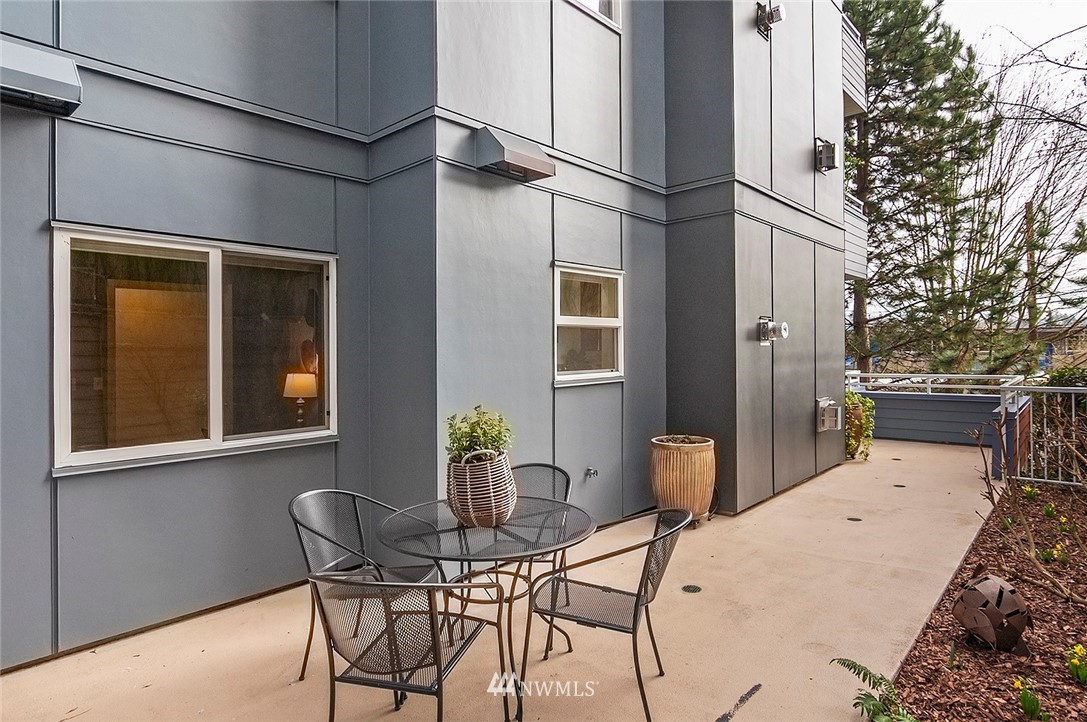 3112 Southwest Avalon Way, Unit 102 Seattle, WA 98126 - Photo 18 of 26 a view of a patio with table and chairs and potted plants