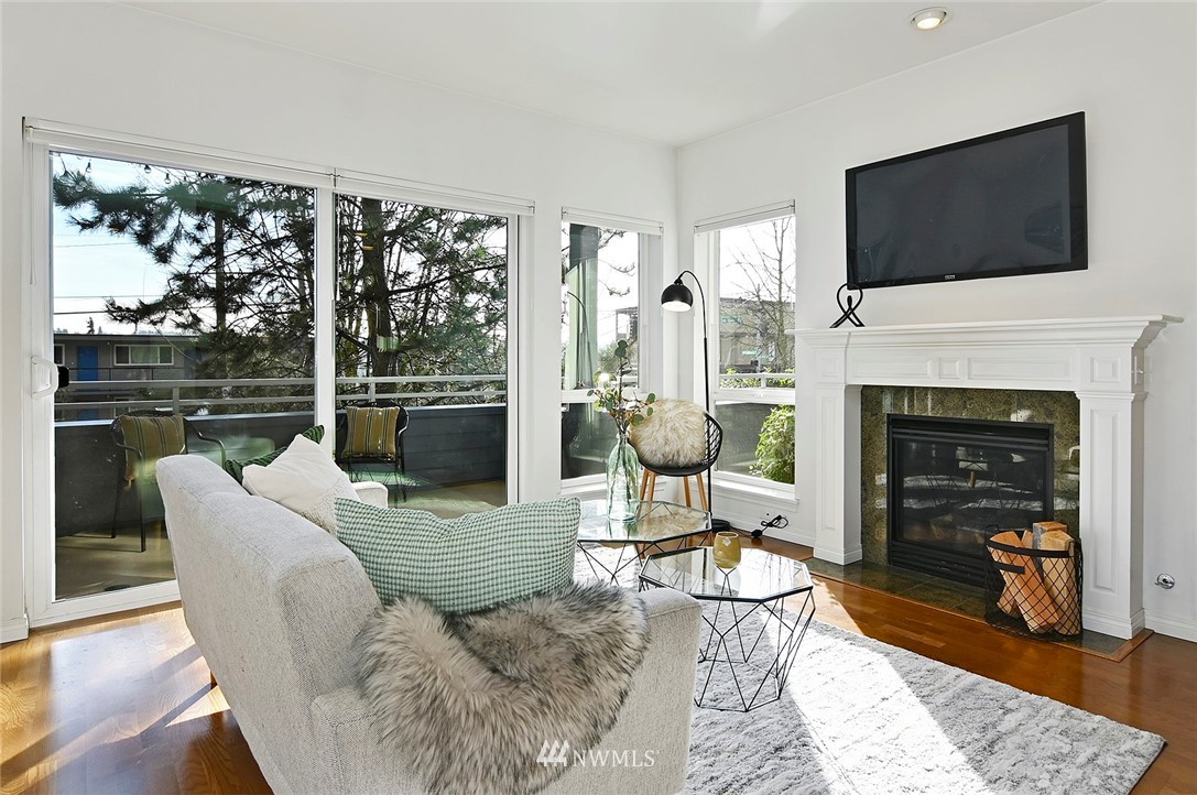 3112 Southwest Avalon Way, Unit 102 Seattle, WA 98126 - Photo 2 of 26 a living room with furniture a flat screen tv and a fireplace