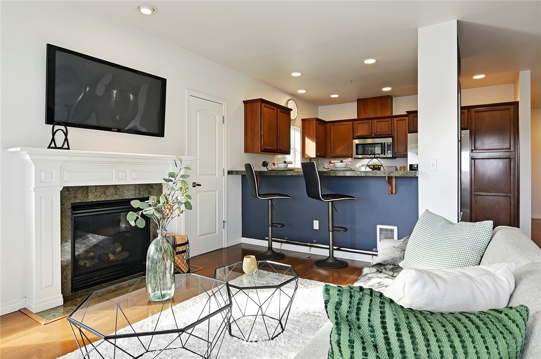 3112 Southwest Avalon Way, Unit 102 Seattle, WA 98126 - Photo 4 of 26 a living room with furniture a flat screen tv and a fireplace