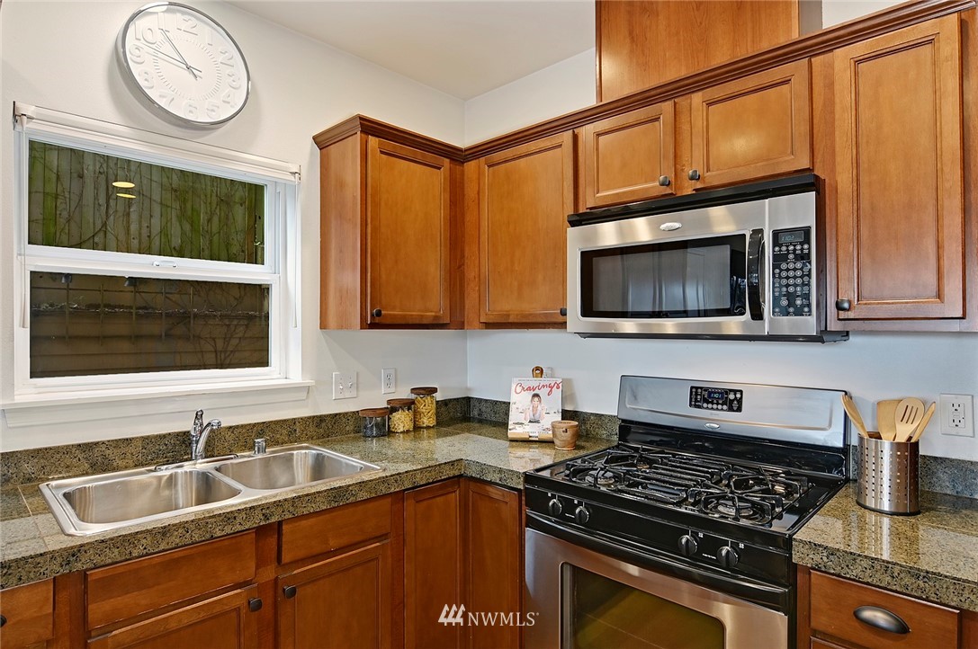 3112 Southwest Avalon Way, Unit 102 Seattle, WA 98126 - Photo 7 of 26 a kitchen with stainless steel appliances granite countertop a sink stove and microwave