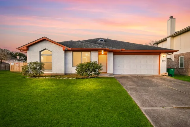 a front view of a house with a garden and plants