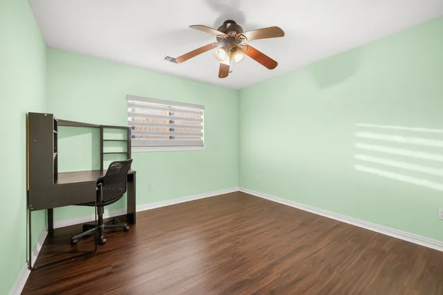 a view of a room with wooden floor lounge chair and windows