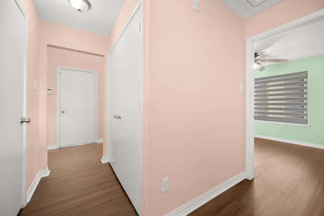 a view of a hallway with wooden floor