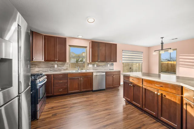 a kitchen with stainless steel appliances sink cabinets and wooden floor
