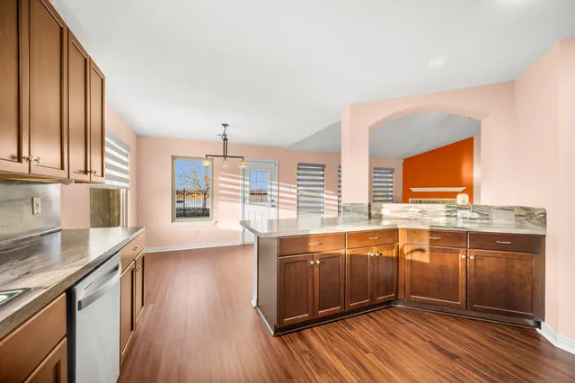 a view of a kitchen with granite countertop a sink and wooden floor