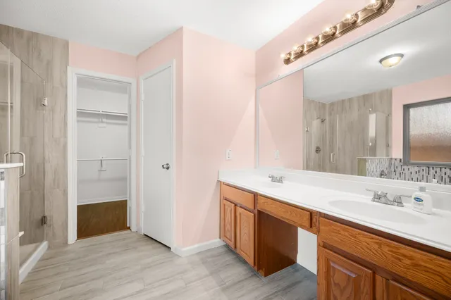 a bathroom with a sink a mirror and a shower