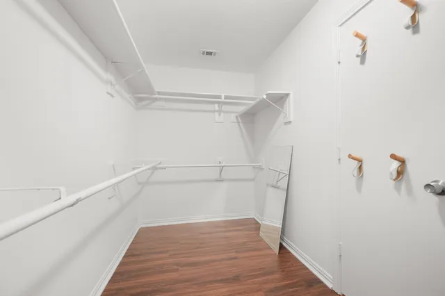 a view of walk in closet with empty racks
