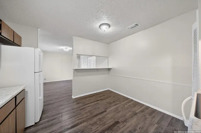 a view of a kitchen with wooden floor and electronic appliances