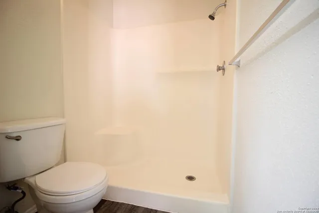 a white toilet sitting next to a shower