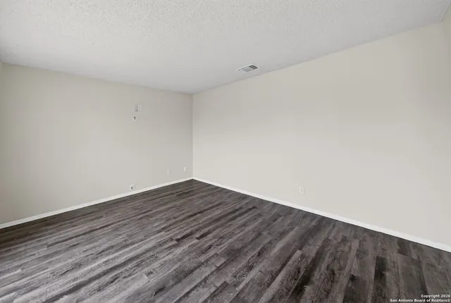 a view of an empty room with wooden floor