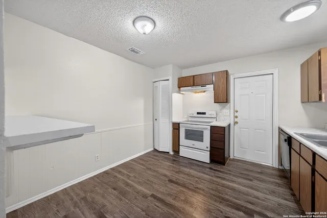 a view of a kitchen with white cabinets and white appliances
