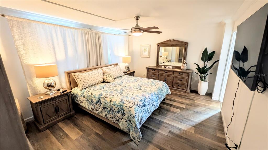 101 South Gulfstream Avenue, Unit 7E Sarasota, FL 34236 - Photo 14 of 40 a bedroom with a bed a flat screen tv and a couch