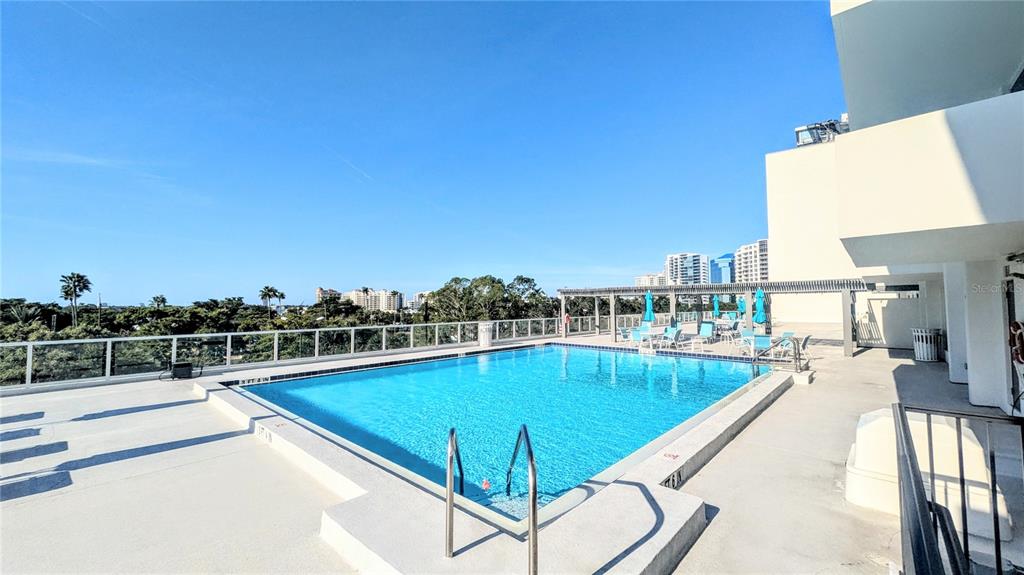 101 South Gulfstream Avenue, Unit 7E Sarasota, FL 34236 - Photo 27 of 40 a view of a swimming pool and lounge chair