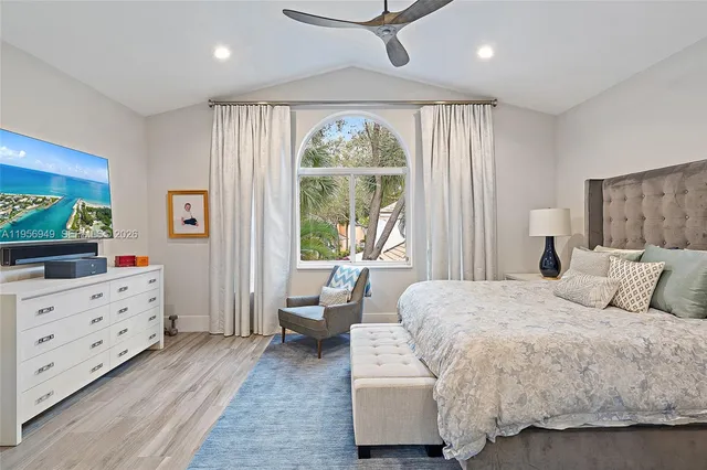 a bedroom with a bed and large windows