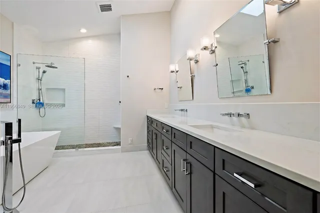 a spacious bathroom with a double vanity sink toilet mirror and bathtub